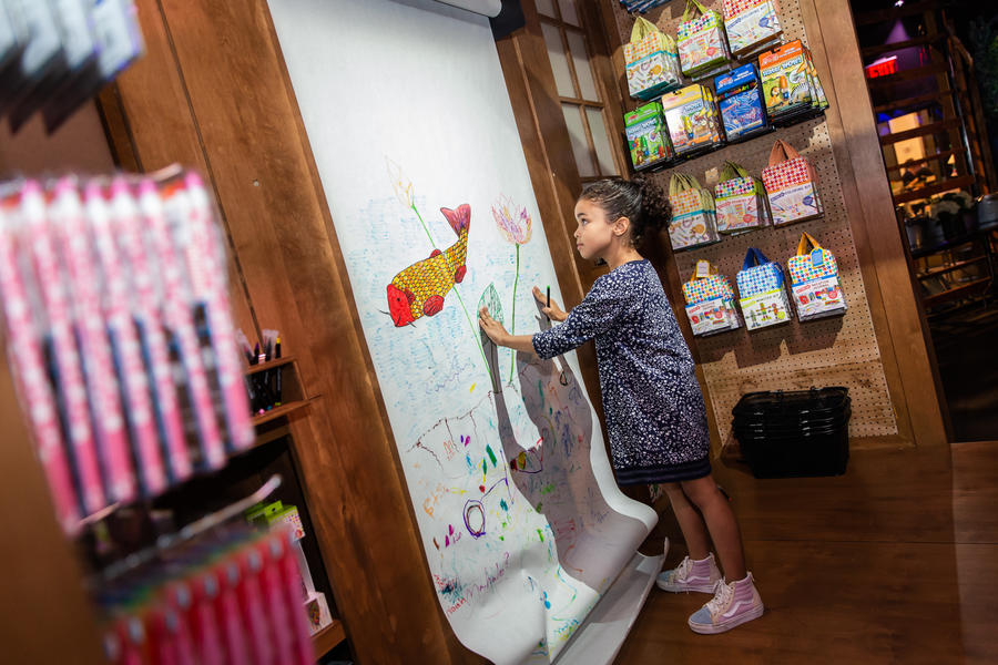 child drawing on large white board