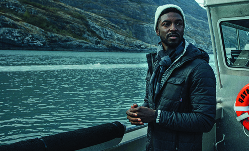 Man wearing a blue coat on a boat