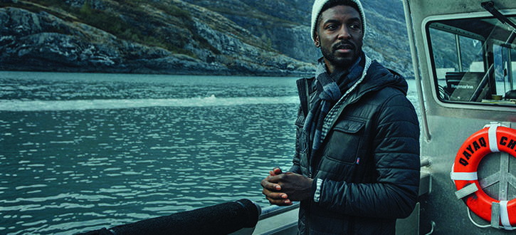 Man wearing a blue coat on a boat