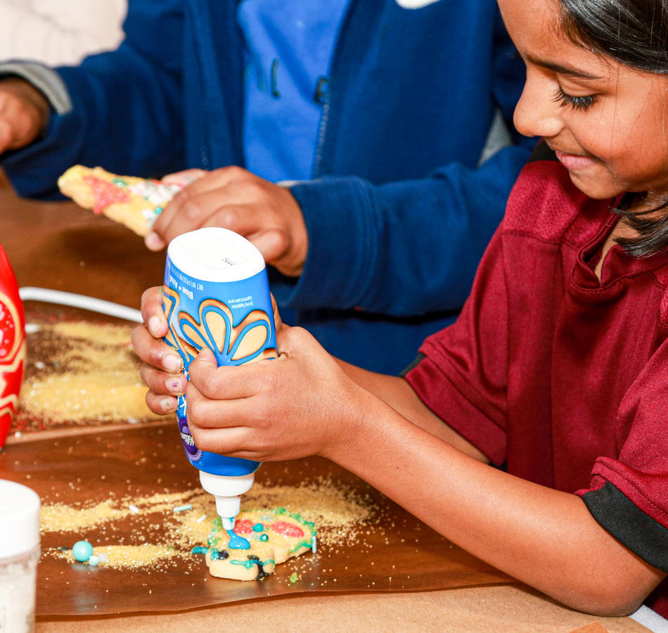 children decorating cookies with icing