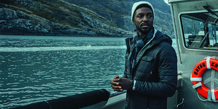 Man wearing a blue coat on a boat